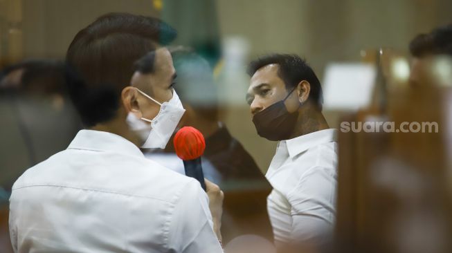 Foto double eksposure Musisi I Gede Ari Astina atau Jerinx SID dengan Adam Deni saat menjalani sidang kasus pengancaman di Pengadilan Negeri Jakarta Pusat, Rabu (12/1/2022). [Kabarindong.com/Alfian Winanto]