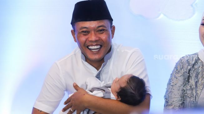 Komedian Entis Sutisna atau Sule sambil menggendong putranya, Adzam Adriansyah Sutisna saat menggelar jumpa pers usai acara akikah di Tambun, Bekasi, Jawa Barat, Jumat (21/1/2022). [Kabarindong.com/Alfian Winanto]