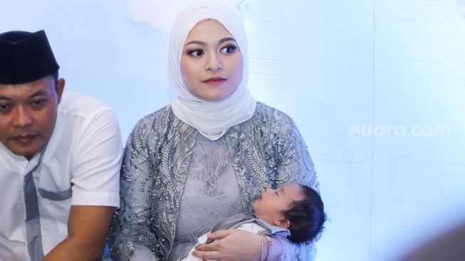 Nathalie Holscher sambil menggendong putranya, Adzam Adriansyah Sutisna saat menggelar jumpa pers usai acara akikah di Tambun, Bekasi, Jawa Barat, Jumat (21/1/2022). [Kabarindong.com/Alfian Winanto]