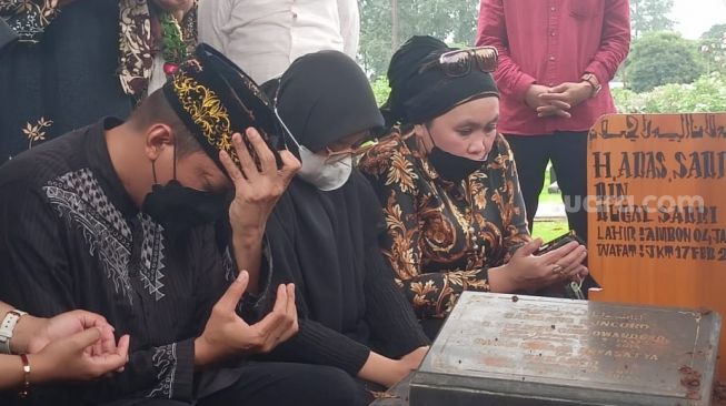 Doddy Sudrajat (kiri) dan Puput Sudrajat di pemakaman sang ayah di TPU Malaka, Pondok Kopi Jakarta Timur, Jumat (18/2/2022). [Rena Pangesti/Kabarindong.com]