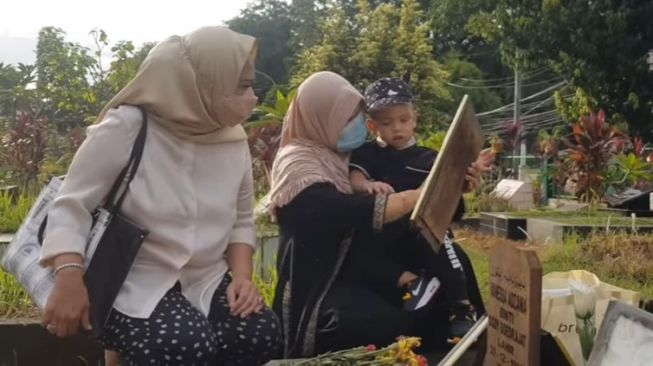 Gala Sky Andriansyah di makam kedua orangtuanya, Vanessa Angel dan Bibi Ardiansyah. [YouTube Intens Investigasi]