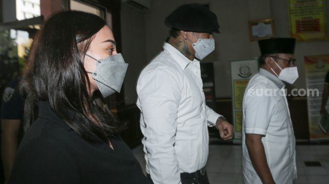 Musisi I Gede Ari Astina atau Jerinx SID bersama sang istri, Nora Alexandra saat tiba untuk pelimpahan berkas (P21) terkait kasus pencemaran nama baik yang menjeratnya di Kejaksaan Negeri Jakarta Pusat, Rabu (1/12/2021). [Kabarindong.com/Alfian Winanto]