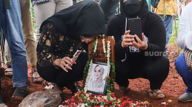 Keluarga berdoa diatas pusara Vanessa Angel dan Suaminya, Bibi Ardiansyah usai dimakamkan di Taman Makam Islam Malaka, Pesanggrahan, Jakarta Selatan, Jumat (5/11/2021). [Kabarindong.com/Alfian Winanto]