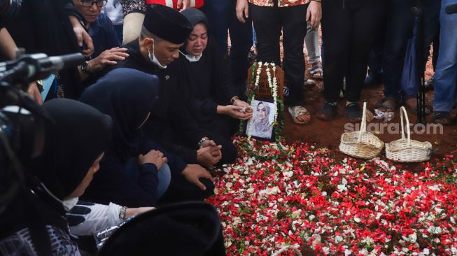 Keluarga berdoa diatas pusara Vanessa Angel dan Suaminya, Bibi Ardiansyah usai dimakamkan di Taman Makam Islam Malaka, Pesanggrahan, Jakarta Selatan, Jumat (5/11/2021). [Kabarindong.com/Alfian Winanto]