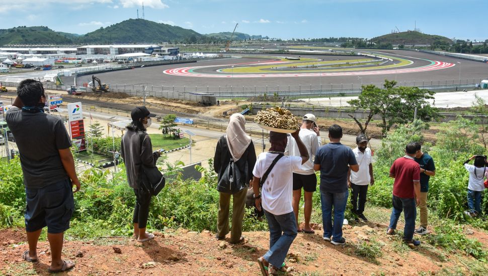 Sejumlah warga menonton sesi tes pramusim MotoGP 2022 dari atas bukit sekitar Pertamina Mandalika International Street Circuit di KEK Mandalika, Desa Kuta, Kecamatan Pujut, Praya, Lombok Tengah, NTB, Sabtu (12/2/2022). [ANTARA FOTO/Ahmad Subaidi/pras]