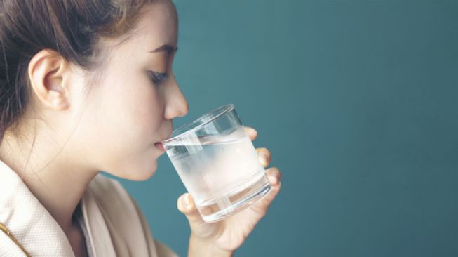 Ilustrasi minum air putih saat perut kosong. (Shutterstock)