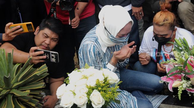 Mantan Politikus Angelina Sondakh berziarah ke makam suaminya, Adjie Massaid di TPU Jeruk Purut, Jakarta, Kamis (3/3/2022). [Kabarindong.com/Angga Budhiyanto]