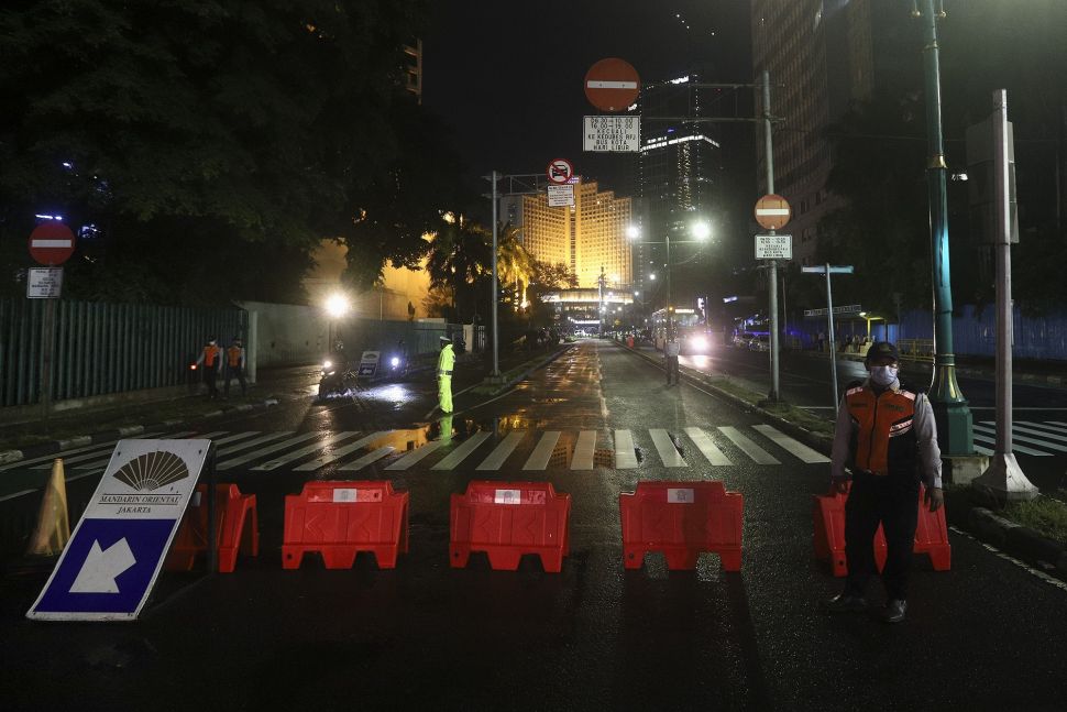 Petugas berjaga saat diberlakukannya Car Free Night (malam bebas kendaraan) dan Crowd Free Night (malam bebas keramaian) pada malam pergantian tahun di kawasan Bundaran HI, Jakarta, Kamis (31/12/2020). [SUara.com/Angga Budhiyanto]