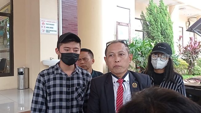 Rozy Zay Hakiki (kemeja kotak-kotak) didampingi pengacara mendatangi Polda Banten, Kamis (5/1/2023) untuk melaporkan mantan istri, Norma Risma. [Kabarindong.com/Rena Pangesti]