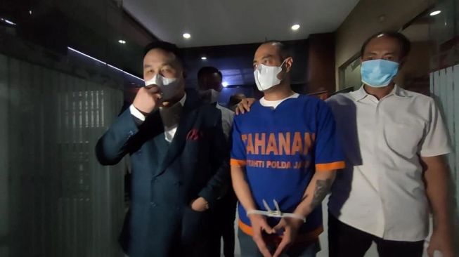 Ferry Irawan ditahan di Polda Jawa Timur dan mengenakan baju tahanan. [Instagram Hotman Paris]