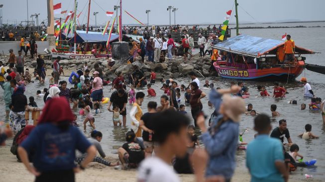 Pengunjung memadati kawasan Pantai Ancol di Taman Impian Jaya Ancol, Jakarta, Selasa (3/5/2022).  ANTARA FOTO/Akbar Nugroho Gumay