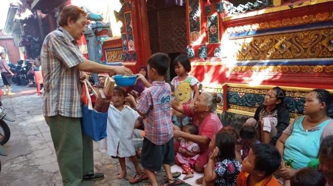 Bagi-bagi angpao di Kelenteng Hong Tiek Hian, Surabaya. (Kabarindong.com/Achmad Ali)